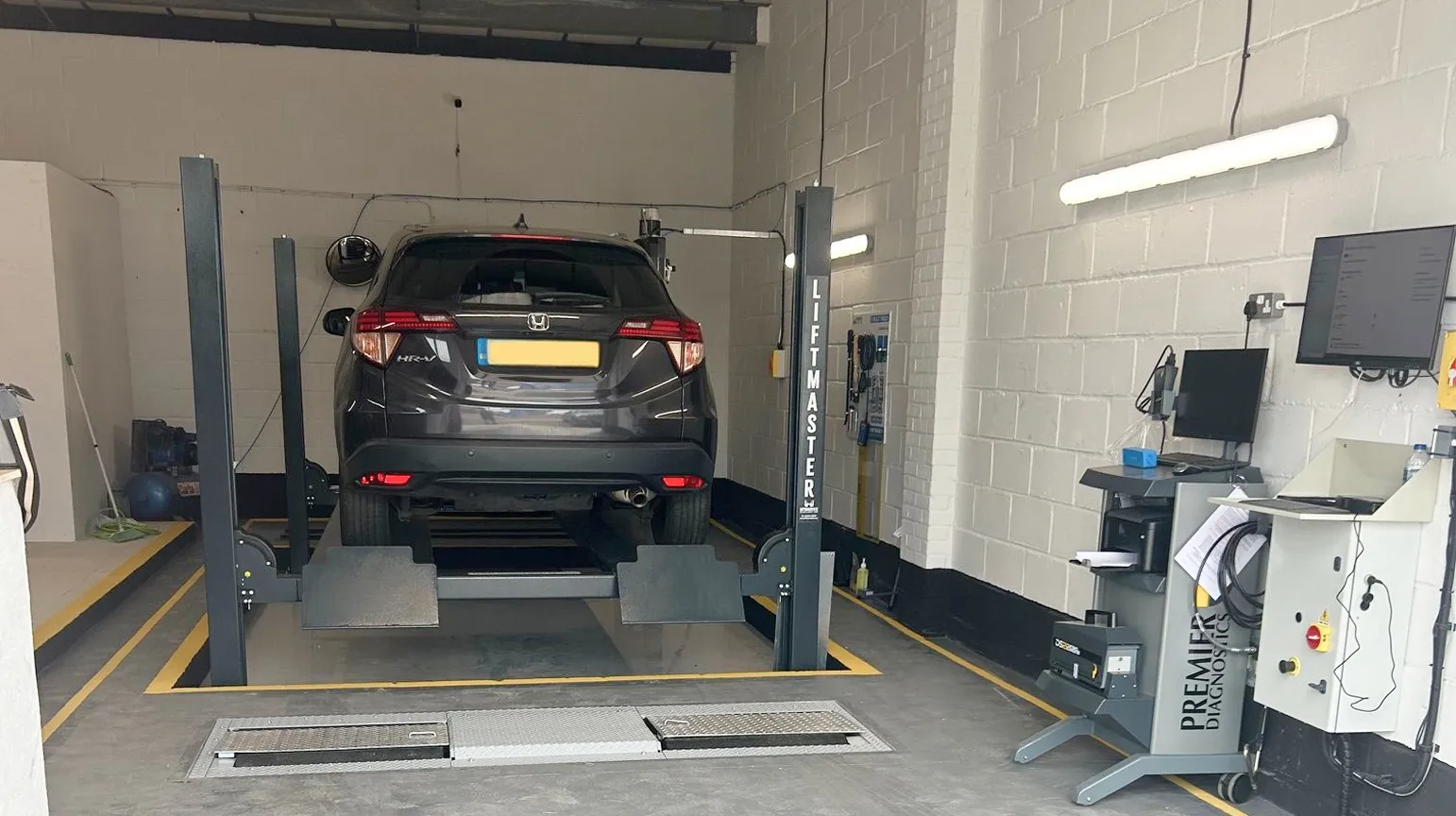 A car raised on a lift in the MOT bay at GM MOT Centre