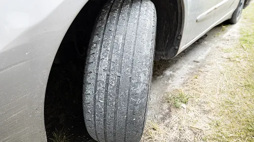 Close-up of a worn car tyre with bald tread