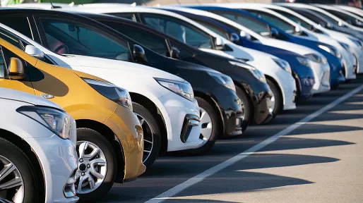 A row of cars parked outside in the sunshine